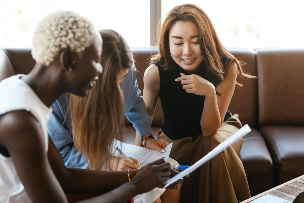 A diverse group of women engage in a collaborative business meeting in an office setting.